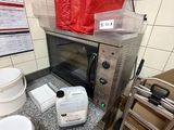 une petite cuisine équipée d'un micro-ondes, d'un grille-pain, de toilettes et d'un sac rouge posé sur le plan de travail
