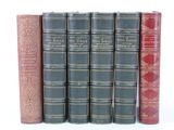 six livres sont alignés sur une surface blanche