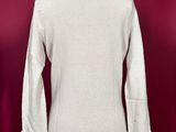 a white sweater on a mannequin stand against a red background