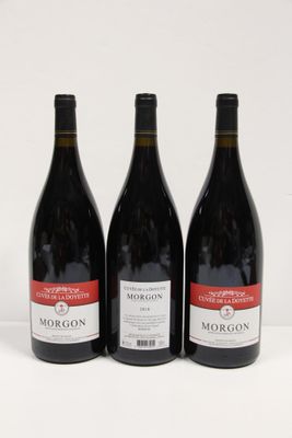 three bottles of red wine are lined up on a white surface