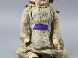 a doll that is sitting on the ground with a hat on