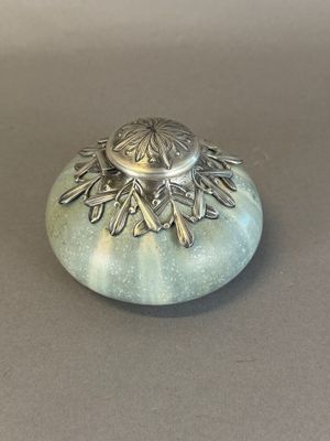 un petit objet en argent posé sur une table