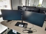 deux écrans posés sur un bureau devant une fenêtre