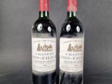two bottles of wine sitting next to each other on a table