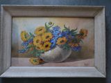 a painting of sunflowers and blue flowers in a white vase
