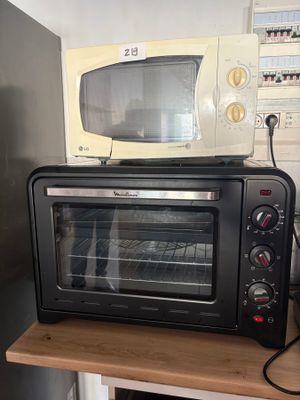 un four grille-pain posé sur un plan de travail en bois