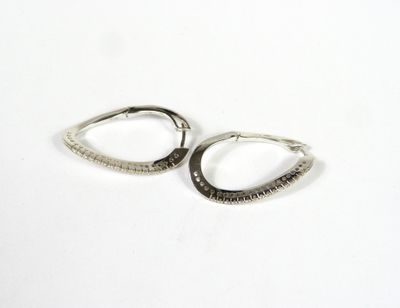 une paire de boucles d'oreilles créoles en argent sur fond blanc