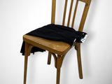 a wooden chair with a black cushion on top of it