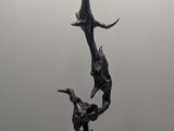 bronze sculpture of a woman and a bird on a marble base
