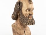an old wooden bust of a man with long hair and a beard