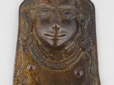 un gros plan d'une plaque métallique sur laquelle figure un visage