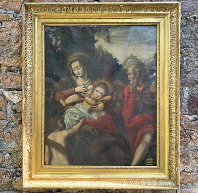 tableau représentant une femme tenant un bébé dans ses bras, dans un cadre doré, accroché à un mur en pierre