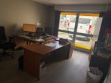 a desk with a computer and a chair in a room
