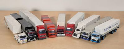 Plusieurs camions miniatures sont alignés en rang sur une table