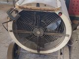 a fan sitting on top of a cart in a warehouse