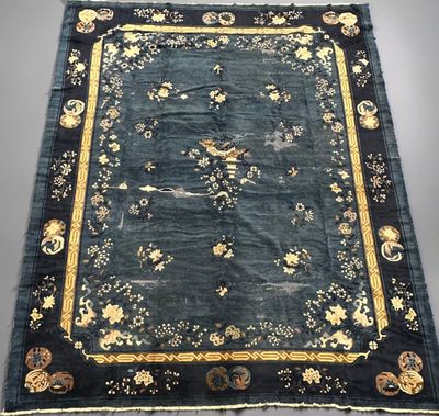 un tapis oriental noir et doré orné d'oiseaux et de fleurs