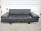 black leather sofa in front of a garage door with a white wall