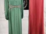 two dresses on a mannequin stand in front of a white wall