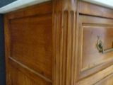 a wooden dresser with a marble top and drawers