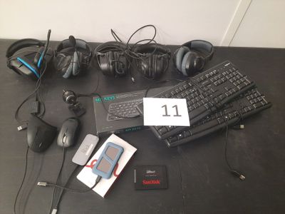 plusieurs casques audio, un clavier, une souris et un téléphone portable posés sur une table