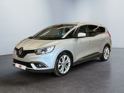 une voiture argentée garée dans une pièce blanche au sol noir
