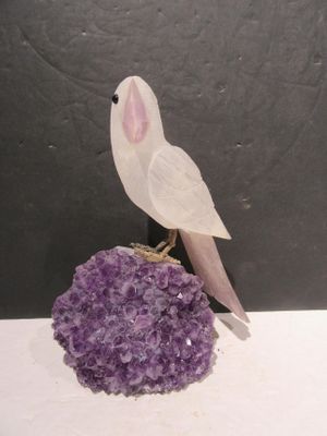 a white bird sitting on top of a purple rock