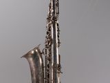 a silver saxophone that is hanging from the ceiling