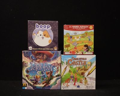 three children ' s board games sitting on top of a black surface