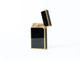 a black and gold lighter sitting on a white surface