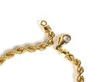 a close up of a gold bracelet on a white background