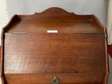 an old wooden desk with a small drawer on top of it