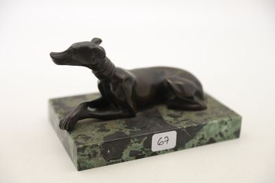 une statue représentant un chien assis sur un socle en marbre