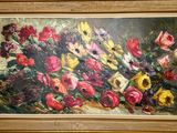 un tableau représentant des fleurs, dans un cadre doré, accroché au mur