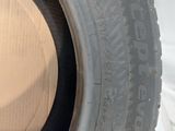 a close up of a tire on a white sheet with a black rim