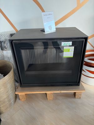 a black microwave sitting on a wooden stand in a room