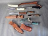 many different types of knives and sheaths laid out on a table