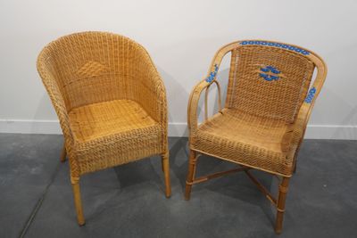 une paire de chaises en osier avec des autocollants bleus sur le dossier