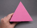 someone is holding a pink paper triangle in their hand