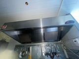 une plaque de cuisson en acier inoxydable à laquelle sont suspendus tout un tas d'ustensiles