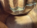 a teddy bear that is sitting on a brown couch