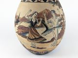 un vase avec une peinture sur une surface blanche