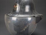 an old helmet with a helmet on top of it sitting on a black surface