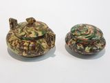 deux petits objets en céramique posés l'un à côté de l'autre sur une surface blanche