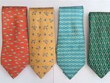 four ties are lined up in a row on a white surface