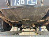 l'arrière d'une voiture dont le pare-chocs porte une plaque d'immatriculation