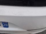 the front bumper of a white car with a number 28 on it