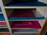 a shelf that has a bunch of folders on it