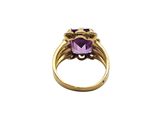 a close up of a gold ring with a purple stone