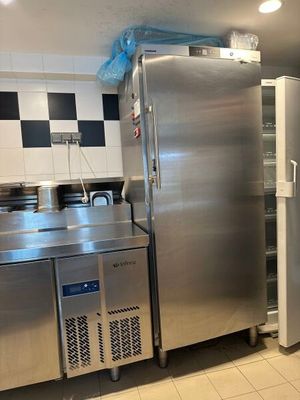 réfrigérateur et congélateur en acier inoxydable dans une cuisine professionnelle aux murs à carreaux