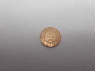 une pièce d'or posée sur une surface blanche
